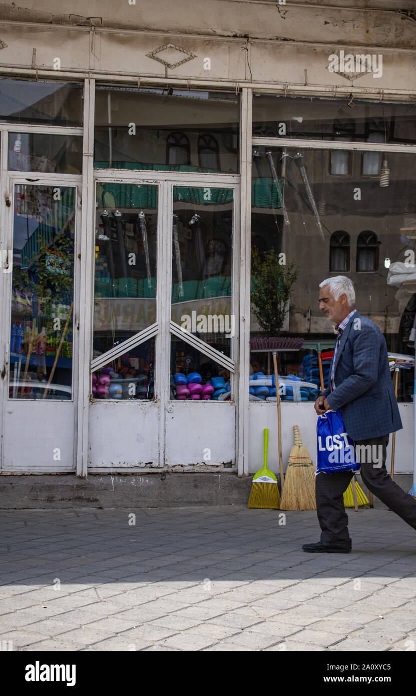 Dogubayazıt, Turchia: locale uomo che porta un sacchetto con la scritta perso camminando su un marciapiede in Dogubayazıt, una cittadina a 15 km a sud-ovest del monte Ararat Foto Stock
