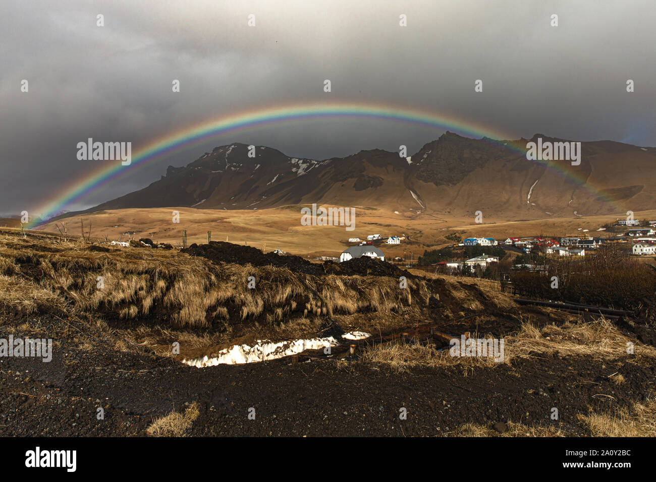 Un perfetto arcobaleno oltre la remota città di Vik, nel sud dell'Islanda Foto Stock
