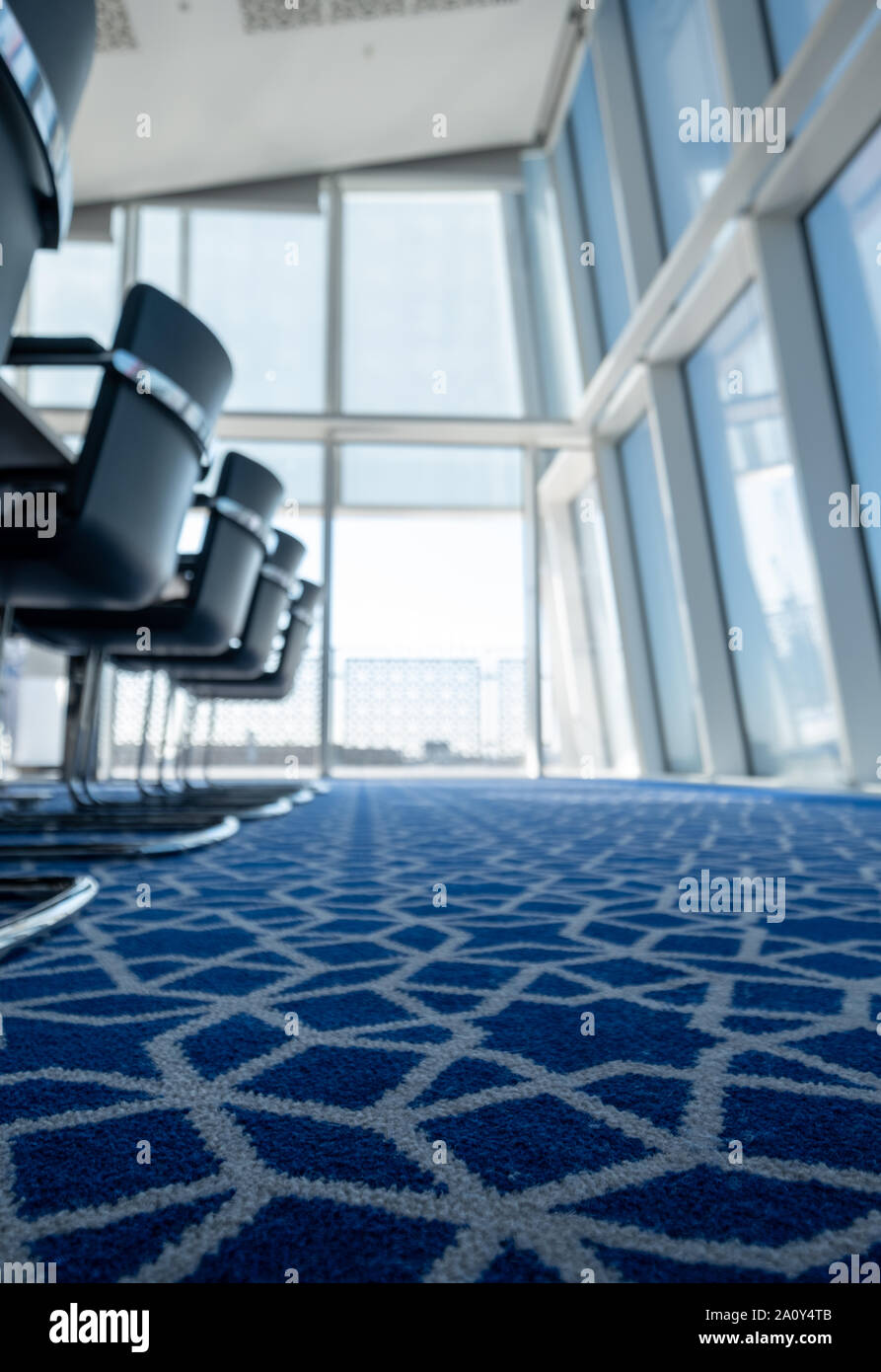 Luce, sunny boardroom con tubolare piegato sedie in acciaio e tappeti blu con disegno geometrico, all'Aga Khan Centro, Kings Cross, London, Regno Unito. Foto Stock