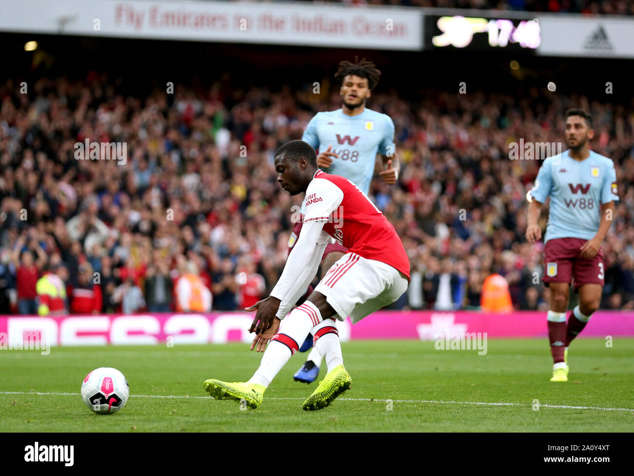 Dell'Arsenal Nicolas Pepe (anteriore) punteggi il suo lato del primo obiettivo del gioco dalla pena spot durante il match di Premier League a Emirates Stadium di Londra. Foto Stock