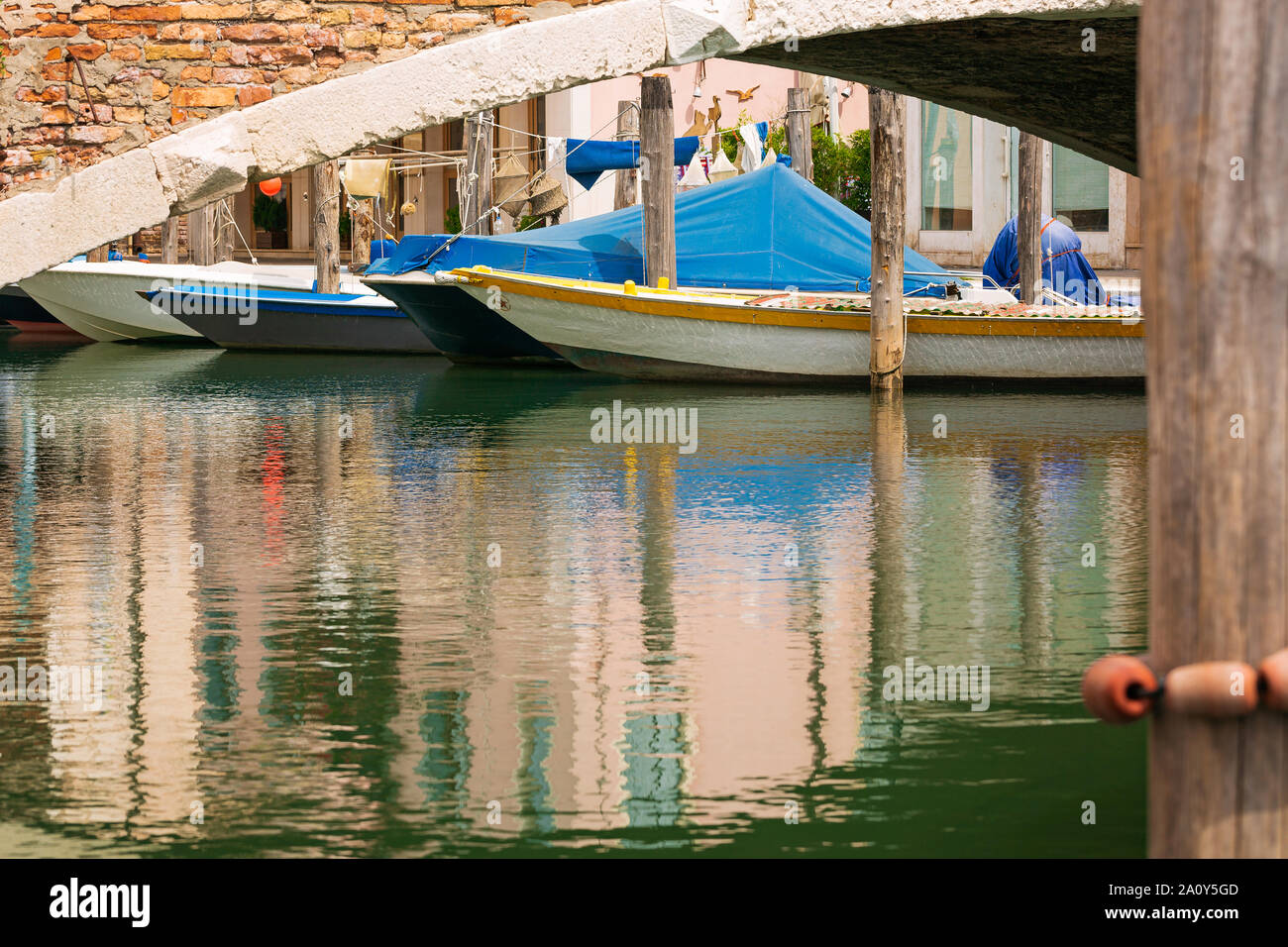 Barche sotto il vecchio ponte di Chioggia città della laguna veneziana. Veneto, Italia, Europa. Foto Stock