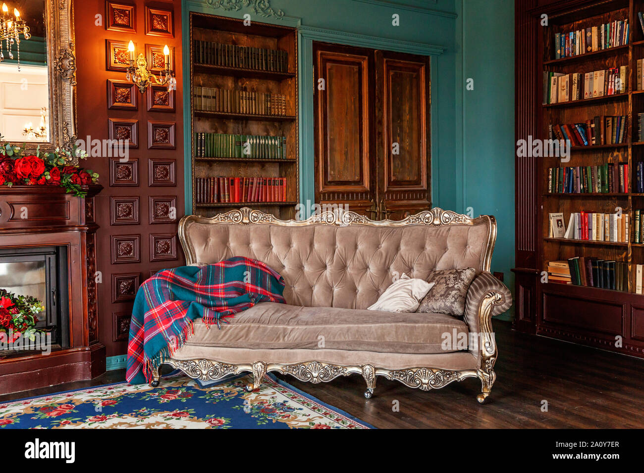 Luxury classic interno della libreria di casa. Salotto con libreria, libri,  poltrona, divano letto e camino.