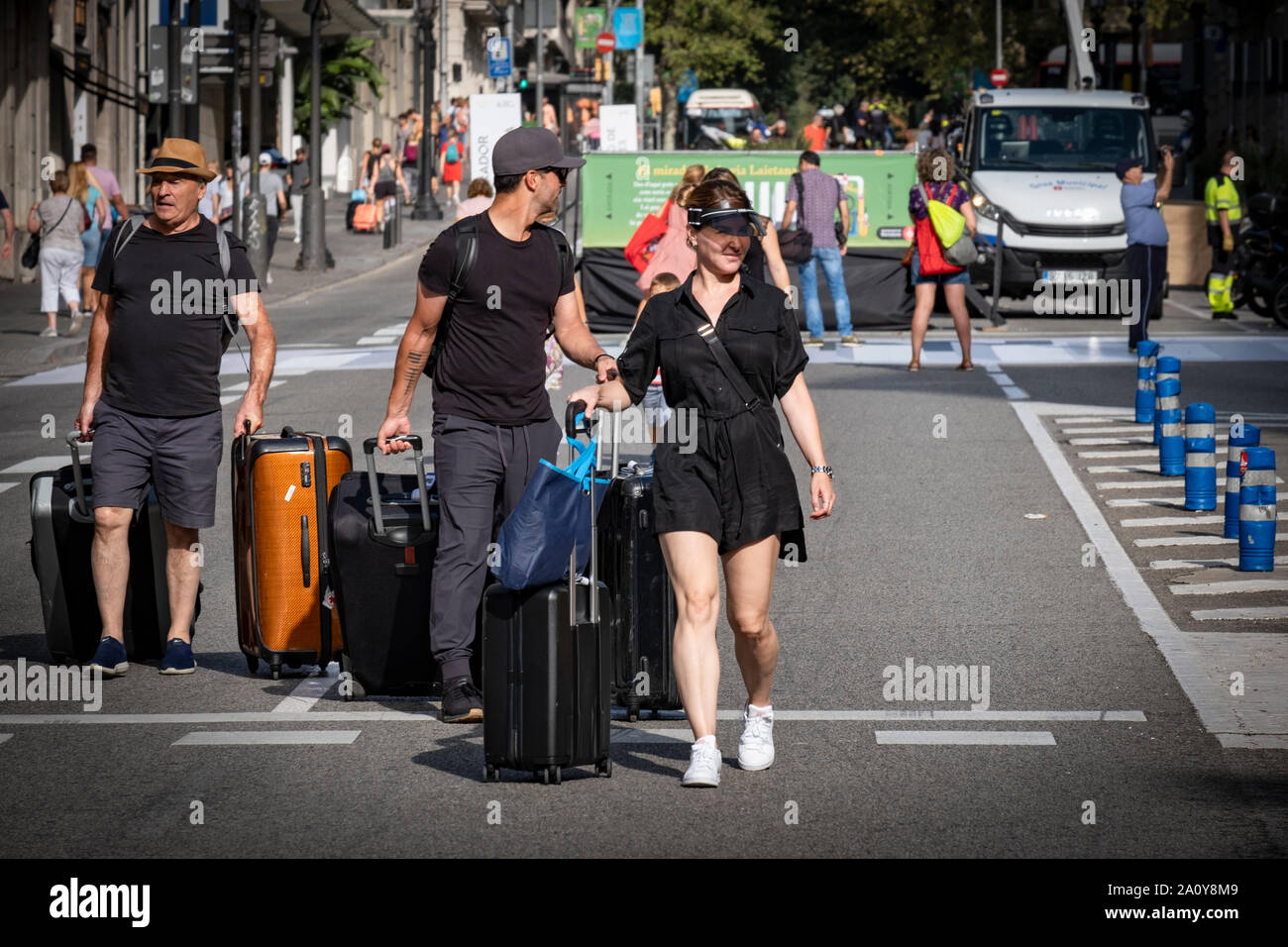 Un gruppo di turisti che arrivano in città sono visti a piedi con le loro valigie attraverso la zona chiusa alla circolazione dei veicoli in Via Laietana per la celebrazione del mondo Car-Free giorno.Barcelona celebra la Giornata mondiale senza auto da condizionare una delle arterie principali della città per l'impiego di cittadini con diverse realtà culturali attività ricreative. Migliaia di cittadini hanno goduto di un giorno di festa in Via Laietana con la circolazione completamente chiusa per veicoli. Foto Stock