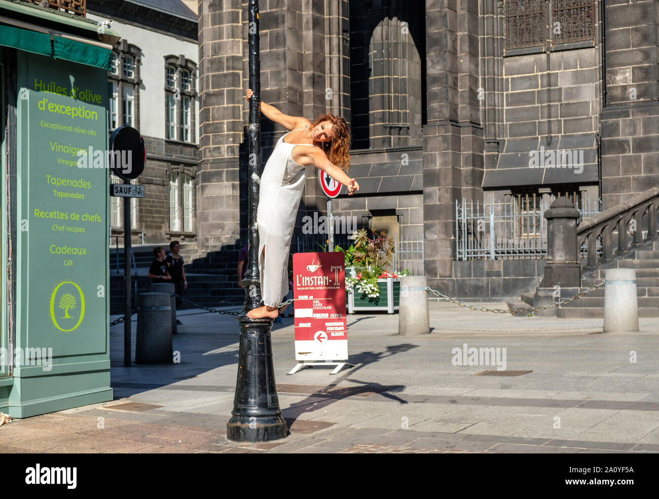 Fotografo modello di fotografare in posa sulla lampada post su Rue des Gras in fronte cattedrale a Clermont-Ferrand, Francia Foto Stock
