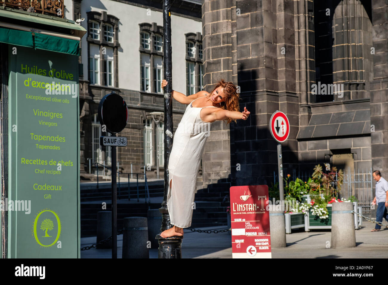 Fotografo modello di fotografare in posa sulla lampada post su Rue des Gras in fronte cattedrale a Clermont-Ferrand, Francia Foto Stock