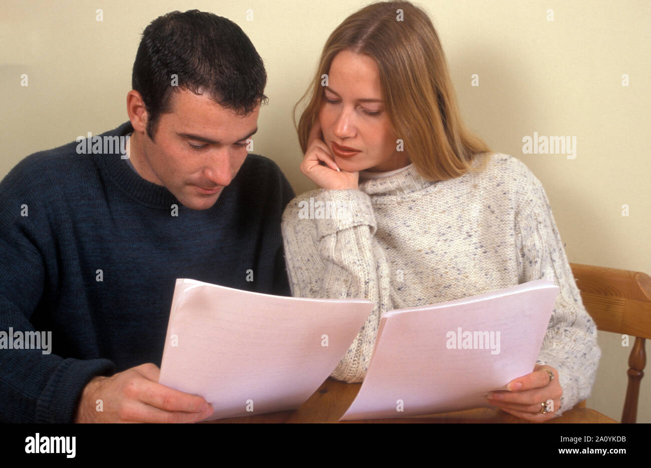 Coppia giovane seduta a tavola la lettura dei documenti Foto Stock
