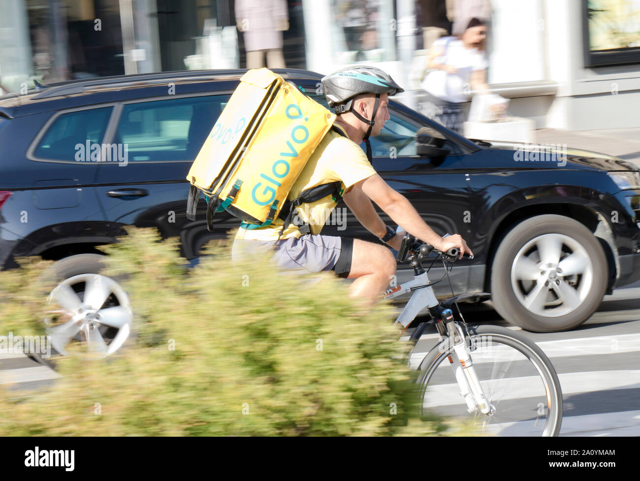 Belgrado, Serbia - 17 Settembre 2019 : un giovane uomo che lavora per Glovo servizio di consegna, una corsa in bicicletta in città il traffico della strada Foto Stock