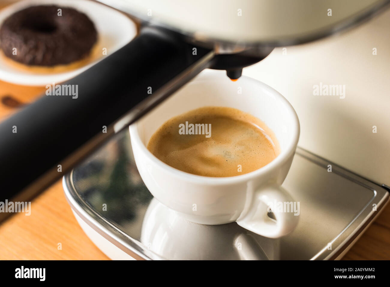 Macchina per caffè espresso e tazza bianca con appena infuso di caffè espresso Foto Stock