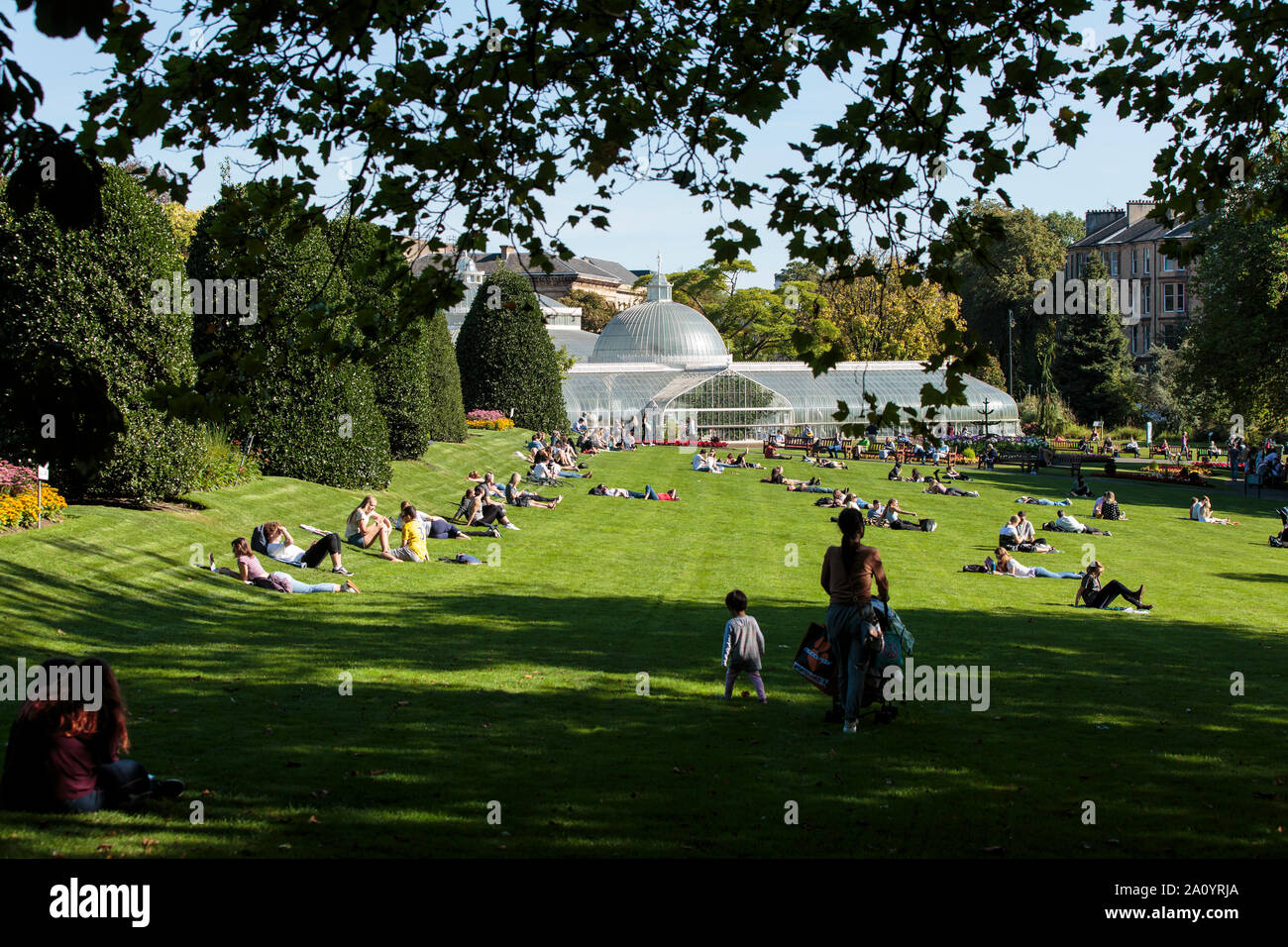 La folla godendo il sole autunnale nel Giardino Botanico nel west end di Glasgow. Foto Stock