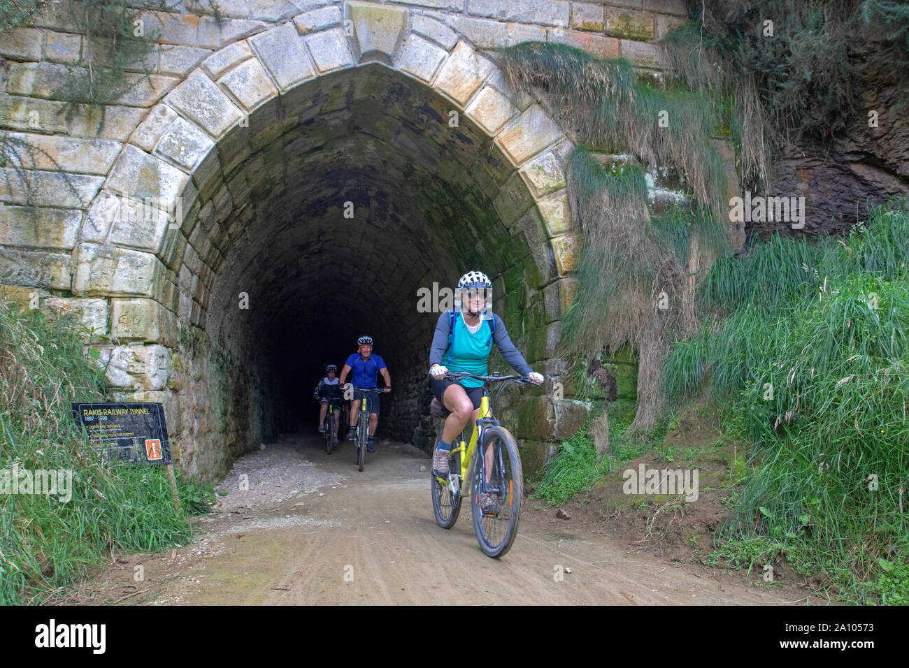 I ciclisti sulle Alpi 2 Ocean trail emergono dal vecchio Rakis tunnel ferroviario Foto Stock