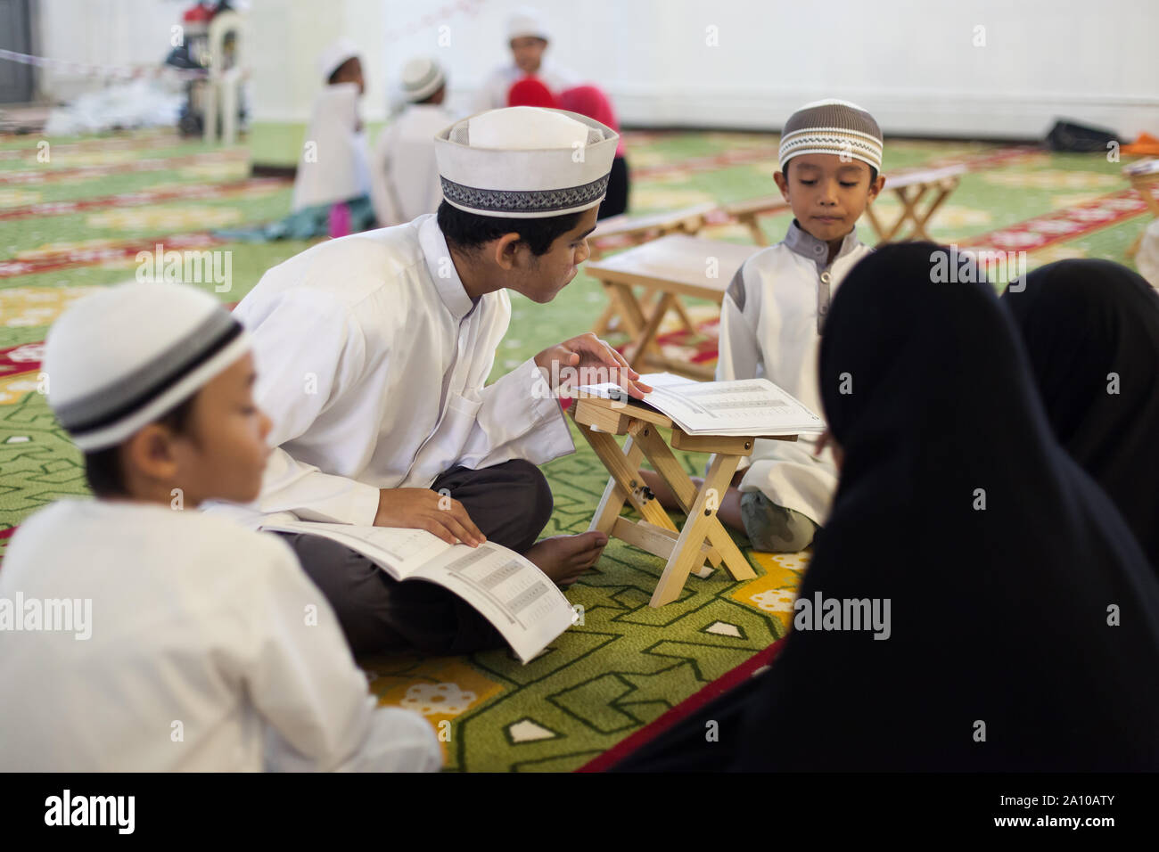 Un religioso del gruppo di studio all'interno di Masjid Moschea del Sultano, Singapore Foto Stock