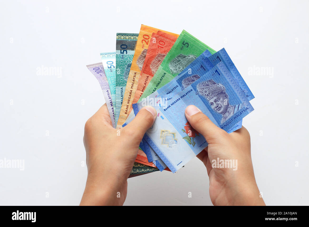 Mano azienda miscela di moneta malese in note contro uno sfondo bianco Foto Stock
