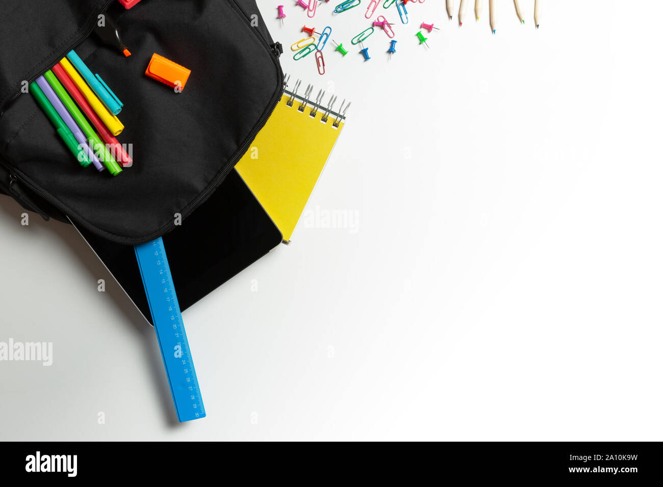 Si torna a scuola concetto. Zaino con forniture scolastiche e tablet Foto Stock