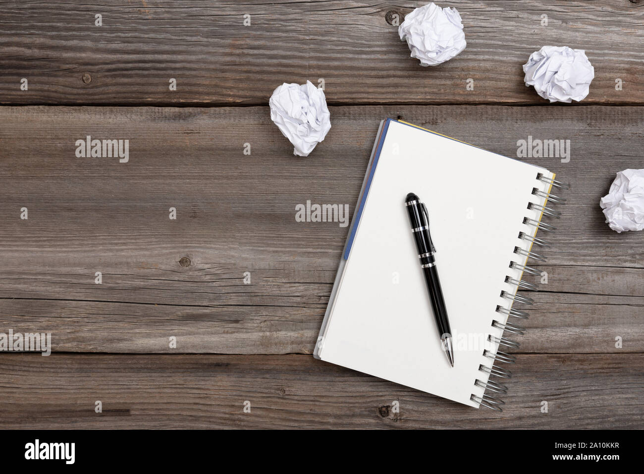 Blocco note e penna con carta sgualcita su sfondo di legno. Nessun concetto di idee Foto Stock