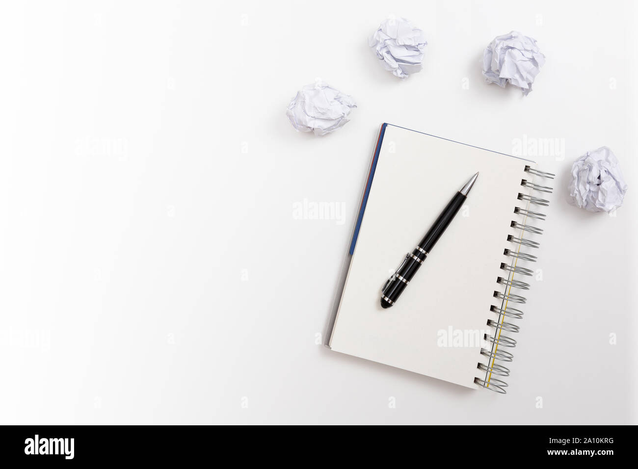 Blocco note e penna con carta sgualcita su sfondo bianco. Nessun concetto di idee Foto Stock