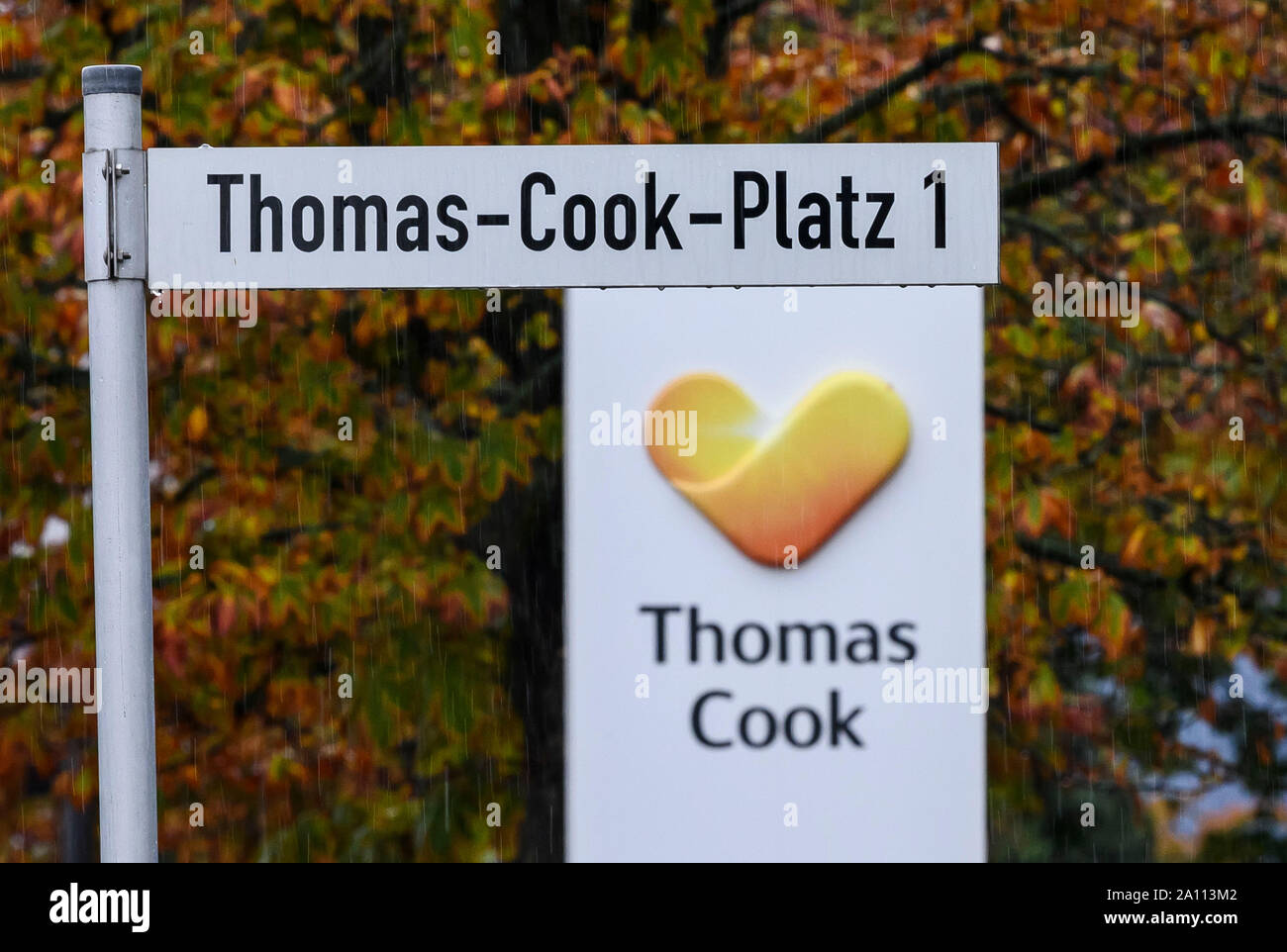 Oberursel, Germania. 23 Sep, 2019. Il logo della British travel società Thomas Cook e un cartello stradale "Thomas Cook Platz 1' di fronte alla sede centrale della filiale tedesca. Gli sforzi di salvataggio della martoriata British turismo di gruppo Thomas Cook hanno fallito. La seconda più grande società di viaggi in Europa ha annunciato che una corrispondente insolvenza petizione era già stata depositata in tribunale. Credito: Sila Stein/dpa/Alamy Live News Foto Stock