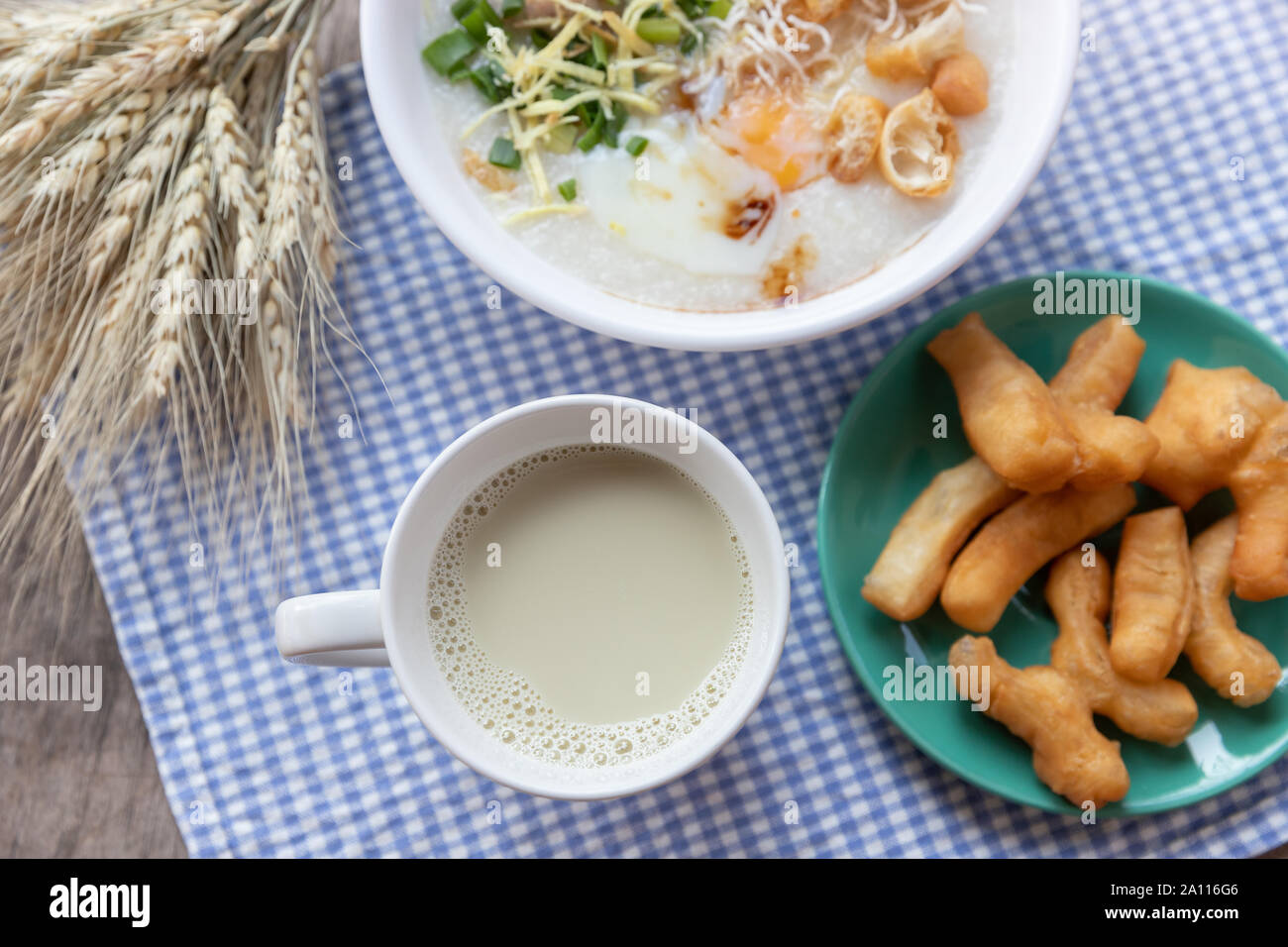 Breakfase pasto. Congee o riso porridge di carne macinata di maiale, uovo sodo con latte di soia e il cinese fritte doppio bastone di pasta Foto Stock