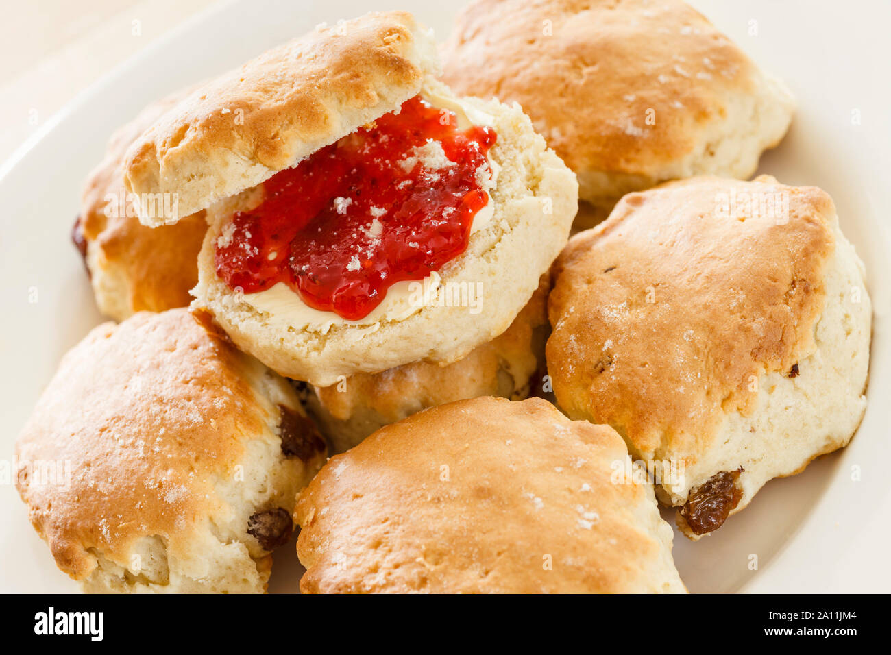 Scones con burro e marmellata su una piastra Foto Stock