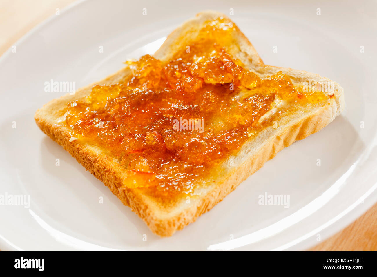 Toast e marmellata su una piastra bianca Foto Stock