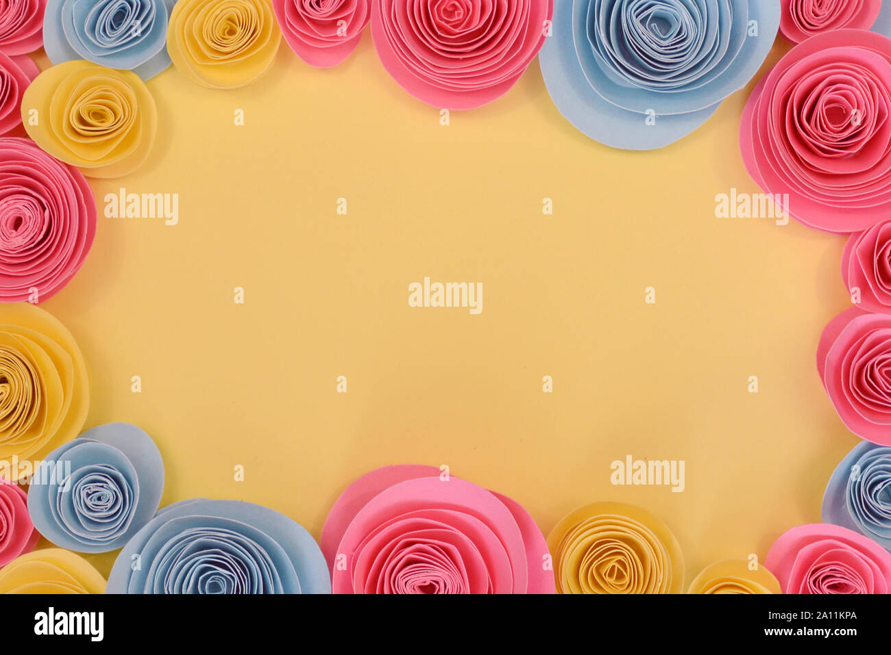 Rosa, giallo e rosa blu piatto telaio laici con predisposti fiori di carta intorno ai bordi e luce vuota copia gialla spazio in medio Foto Stock