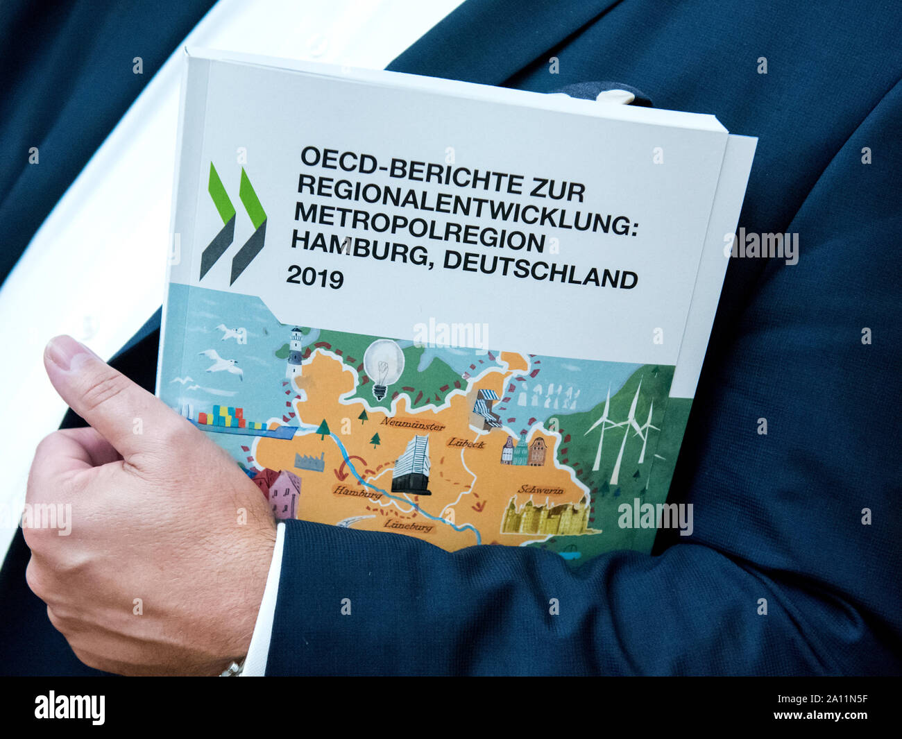 23 settembre 2019, Bassa Sassonia, Seevetal: Un uomo mantiene una relazione dell'OCSE sullo sviluppo di Amburgo regione metropolitana nelle sue braccia. Nelle sue relazioni, l'OCSE fornisce più di 50 raccomandazioni concrete per azione in sei aree tematiche di innovazione, di istruzione e di lavoratori qualificati, il processo di digitalizzazione, alloggiamento e la pianificazione dei trasporti, delle energie rinnovabili e culturali e di marketing turistico. (Sul dpa " OCSE fornisce raccomandazioni per lo sviluppo della regione metropolitana di Amburgo") Foto: Daniel Bockwoldt/dpa Foto Stock