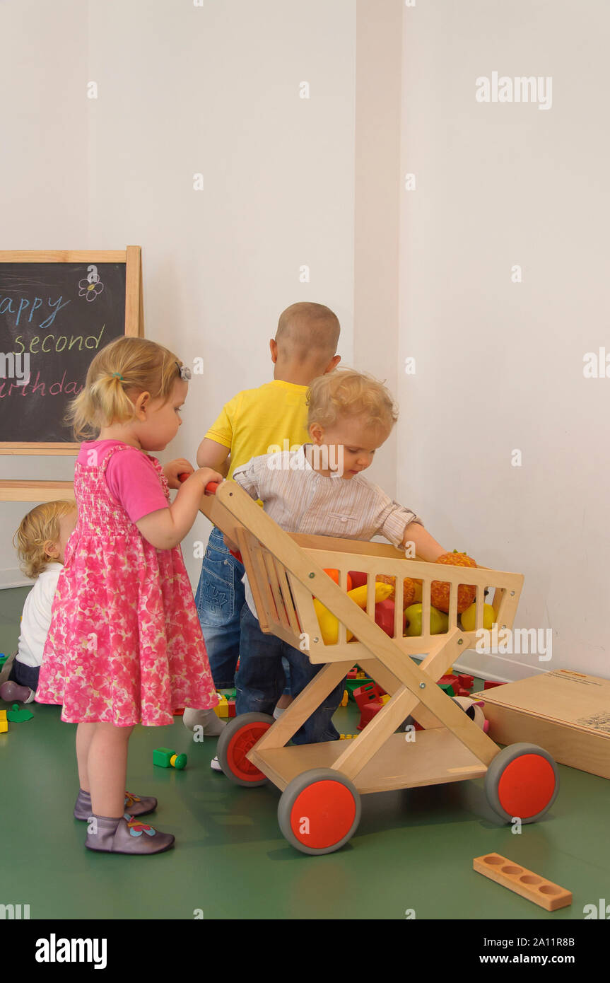 Autentica scena con un po' di bambini che giocano al chiuso in un capretto del partito Foto Stock