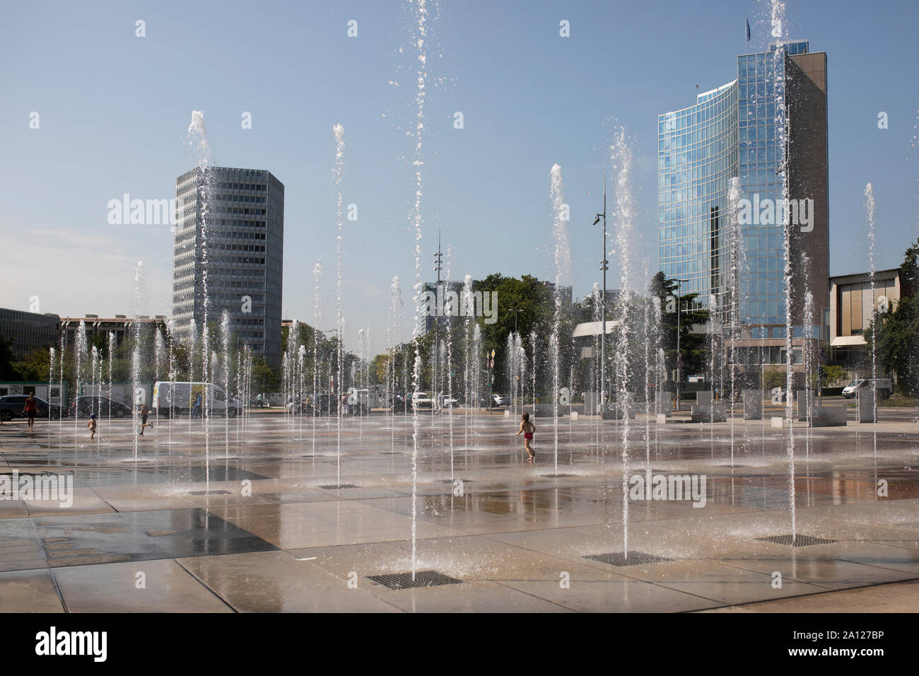 I bambini in esecuzione attraverso le fontane in estate presso la Place des Nations vicino all'ONU (Nazioni Unite) sede a Ginevra, Svizzera. Foto Stock