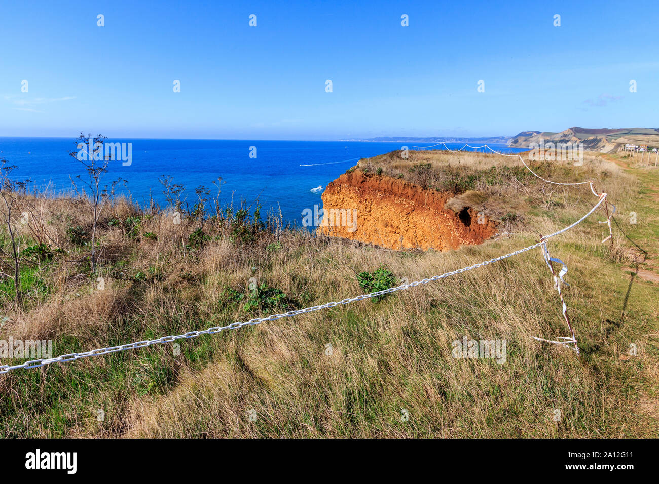 Cliff cade spazio cintato pericolo, West Bay resort costa, Jurassic Coast, sbriciolare scogliere di arenaria,sito UNESCO, Dorset, England, Regno Unito, GB Foto Stock