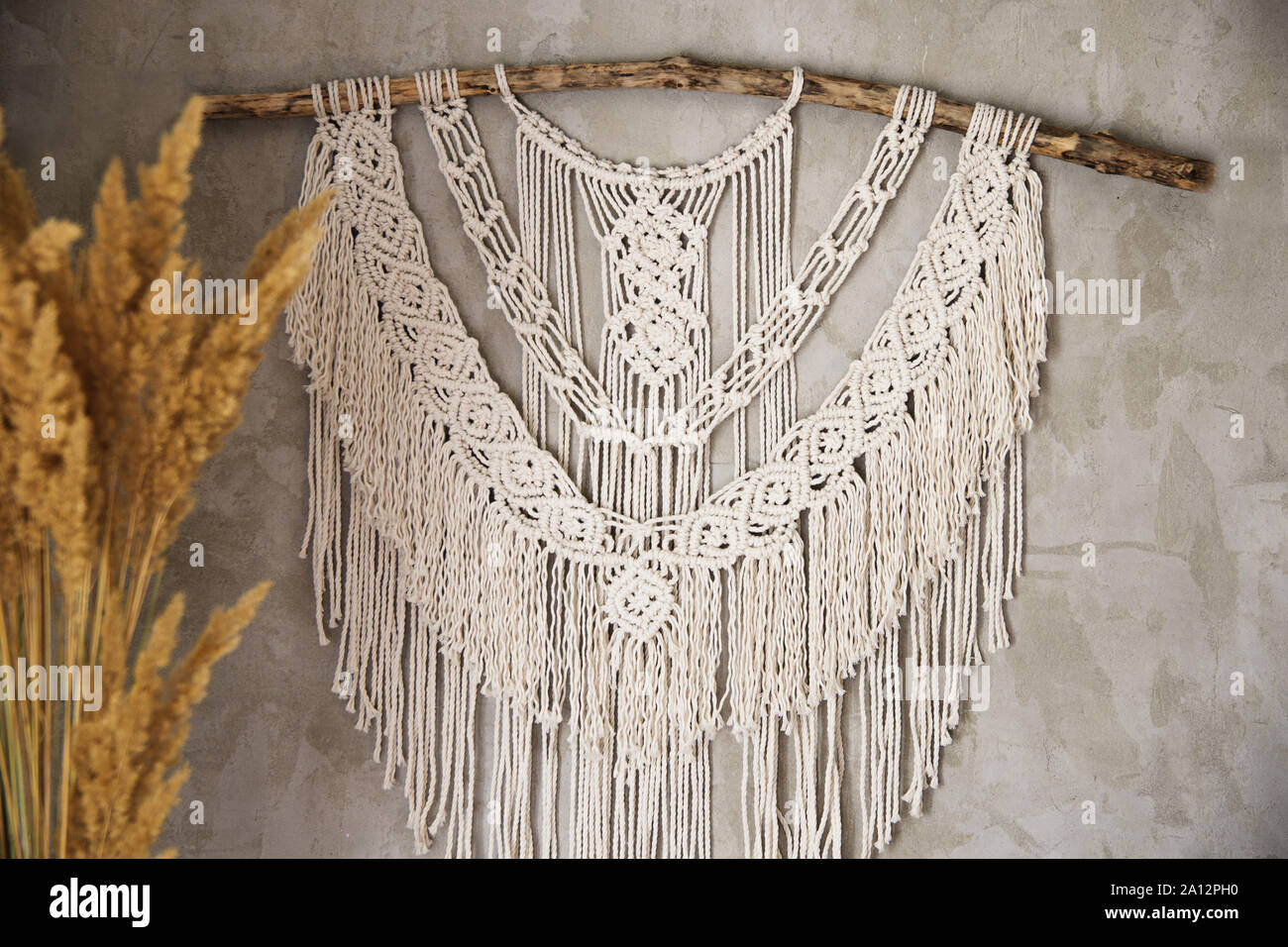 Il pannello a parete in stile Boho fatta di fili di cotone in colore naturale utilizzando la tecnica di macrame per arredamento e decorazioni per matrimoni. Bellissimo b Foto Stock