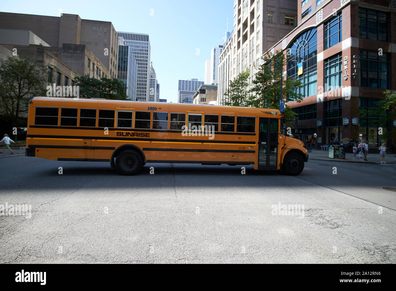 Navistar sunrise charter school bus in ombra attraversamento di incrocio nel centro di chicago, illinois, Stati Uniti d'America Foto Stock