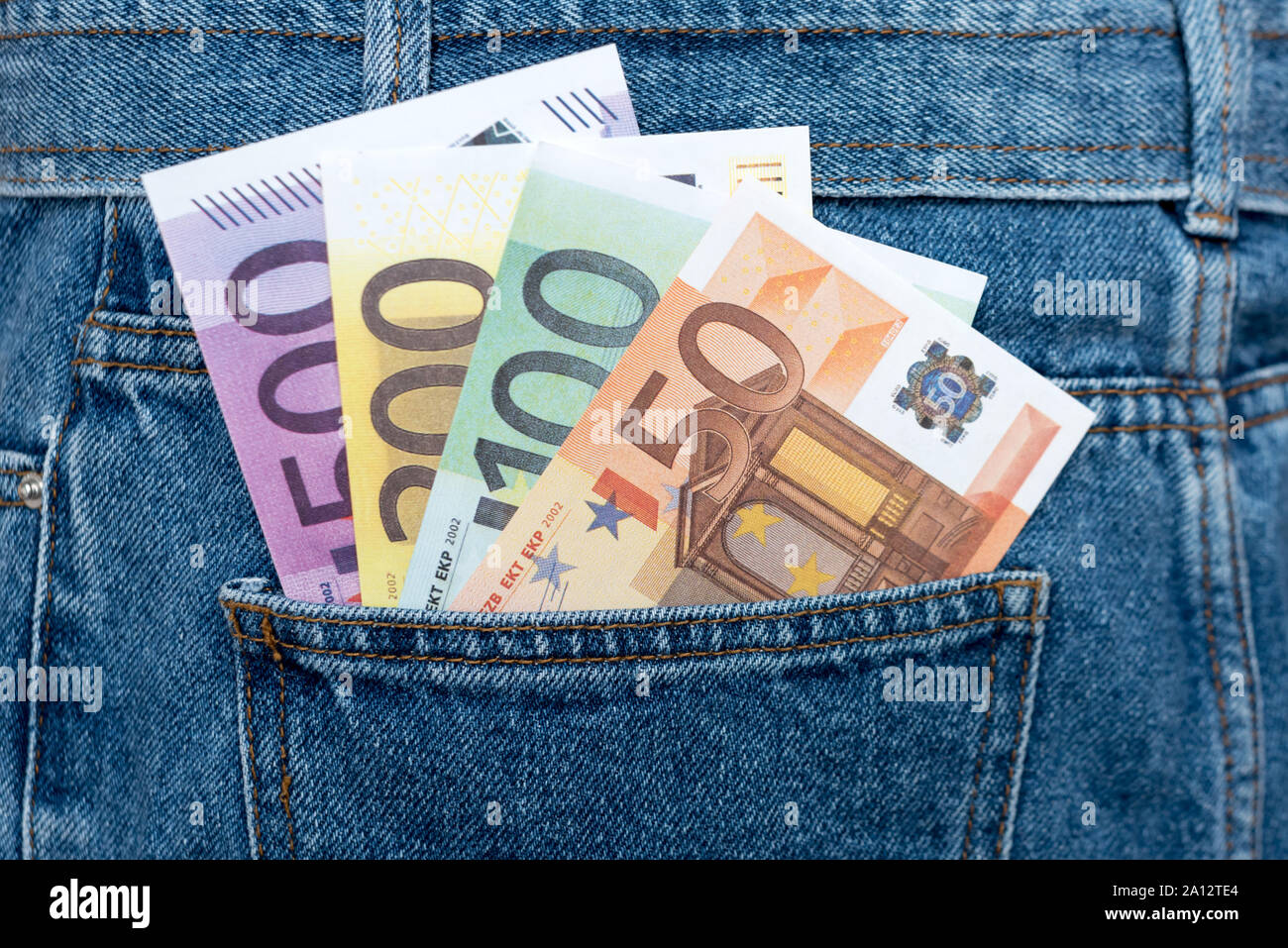 Le banconote in euro in jeans tasca posteriore. Dimenticato il denaro, nido uovo. Concetto di risparmio o di spendere del denaro. Euro Bills cadano fuori. Facile per pickpocket ladro Foto Stock