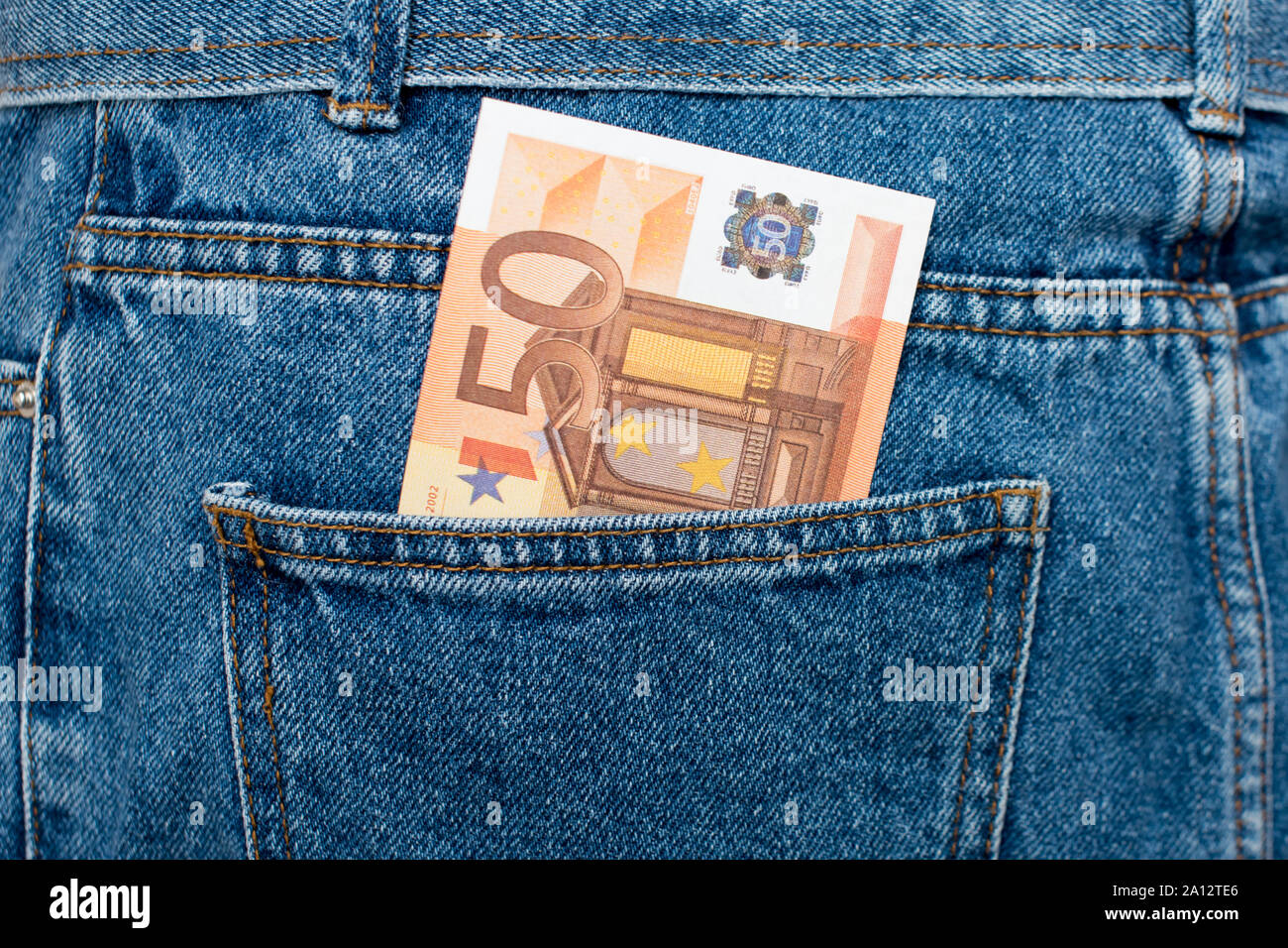 Le banconote in euro in jeans tasca posteriore. Dimenticato il denaro, nido uovo. Concetto di risparmio o di spendere del denaro. Euro Bills cadano fuori. Facile per pickpocket ladro Foto Stock