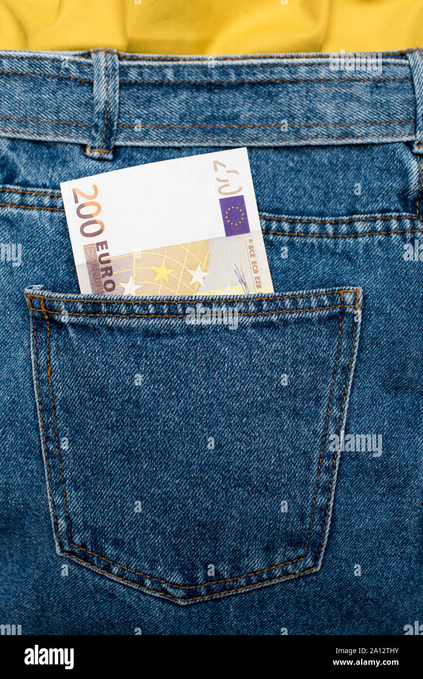 Le banconote in euro in jeans tasca posteriore. Dimenticato il denaro, nido uovo. Concetto di risparmio o di spendere del denaro. Euro Bills cadano fuori. Facile per pickpocket ladro Foto Stock