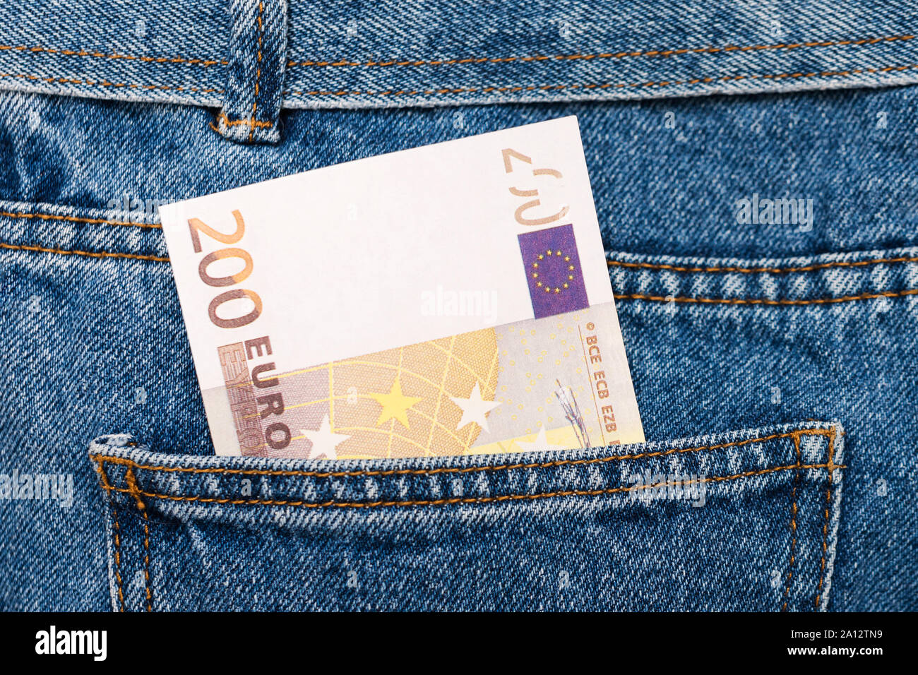 Le banconote in euro in jeans tasca posteriore. Dimenticato il denaro, nido uovo. Concetto di risparmio o di spendere del denaro. Euro Bills cadano fuori. Facile per pickpocket ladro Foto Stock