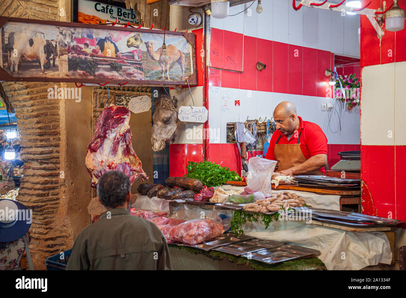 Butcher nel souk fes medina marocco vendita di carne di cammello con testa di cammelli sul display Foto Stock