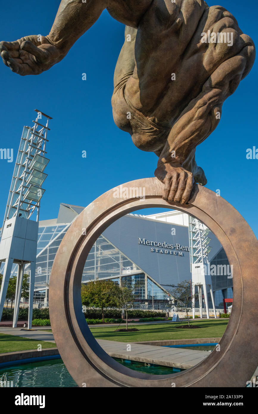 Mercedes-Benz Stadium visto attraverso l'anello olimpico del Flair scultura in bronzo di Richard MacDonald presso la Georgia International Plaza in Atlanta, GA. Foto Stock