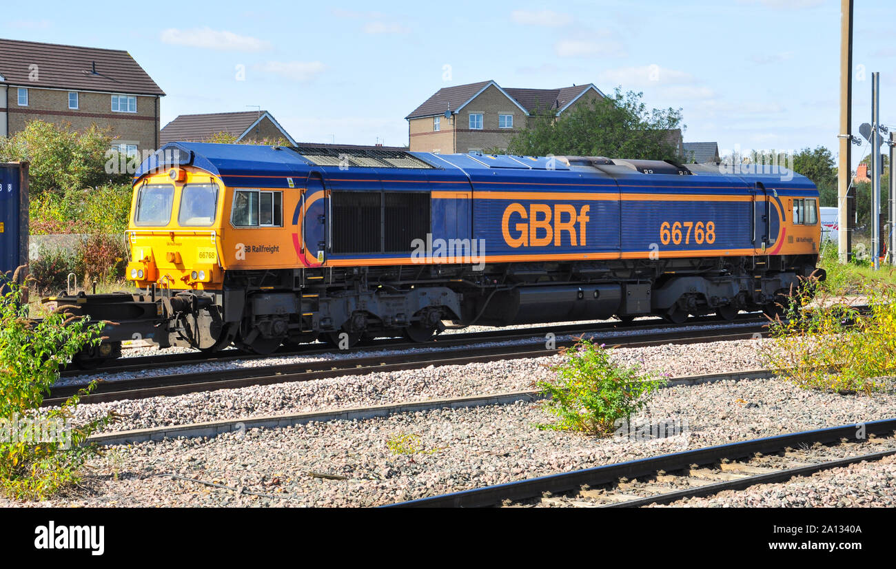 GB classe di merci su rotaie 66 locomotiva diesel capi di un trasporto merci in direzione nord attraverso Peterborough, Cambridgeshire, Inghilterra Foto Stock