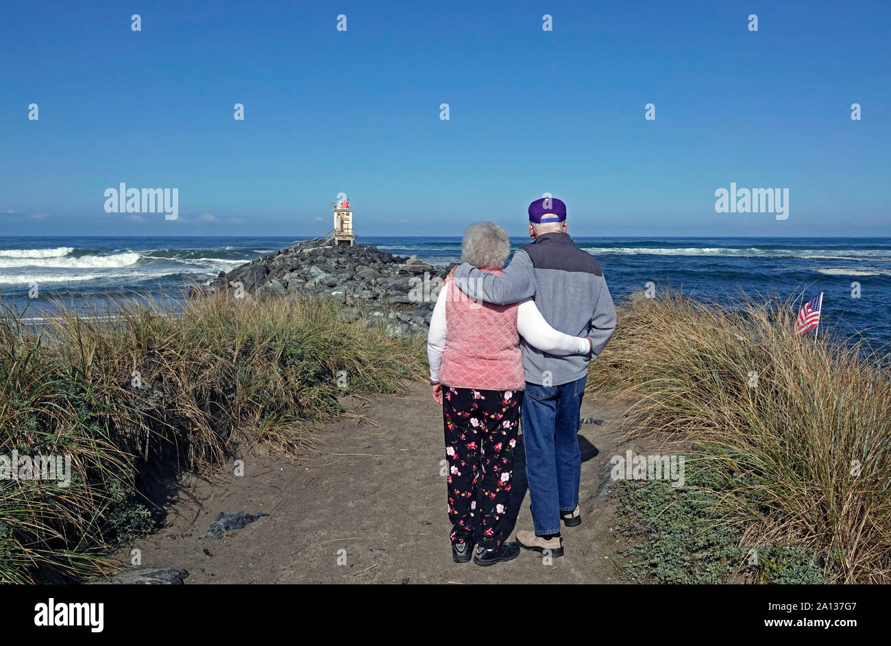 Una coppia di anziani lean su ogni altro mentre il pagamento di un tributo ad un parente stretto che è stata persa per loro di recente, in Bandon, Oregon lungo la costa del Pacifico Foto Stock