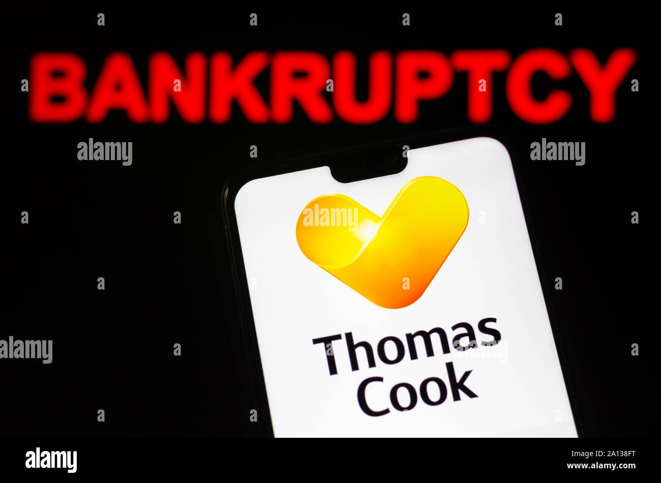 Thomas Cook Group logo sullo smartphone e parola rosso di "fallimento" in background. A titolo illustrativo per le notizie su società di viaggi per la liquidazione. Foto Stock