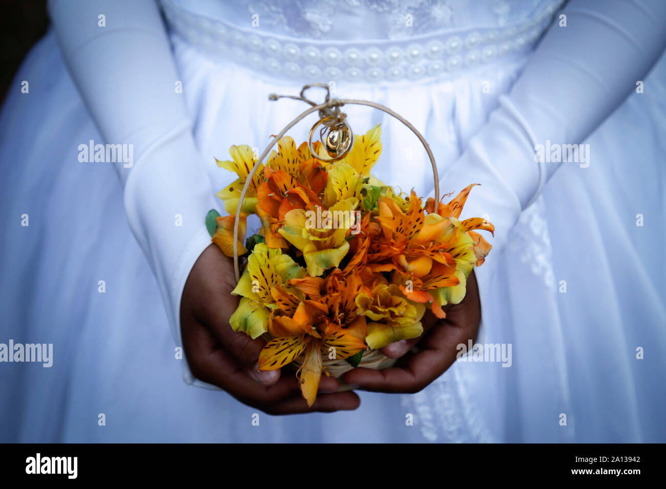 Bambino mani bouquet con gli anelli di nozze, dettaglio della damigella della mano che tiene la disposizione con gli anelli di nozze, gli anelli di nozze, gioielli, uniti han Foto Stock