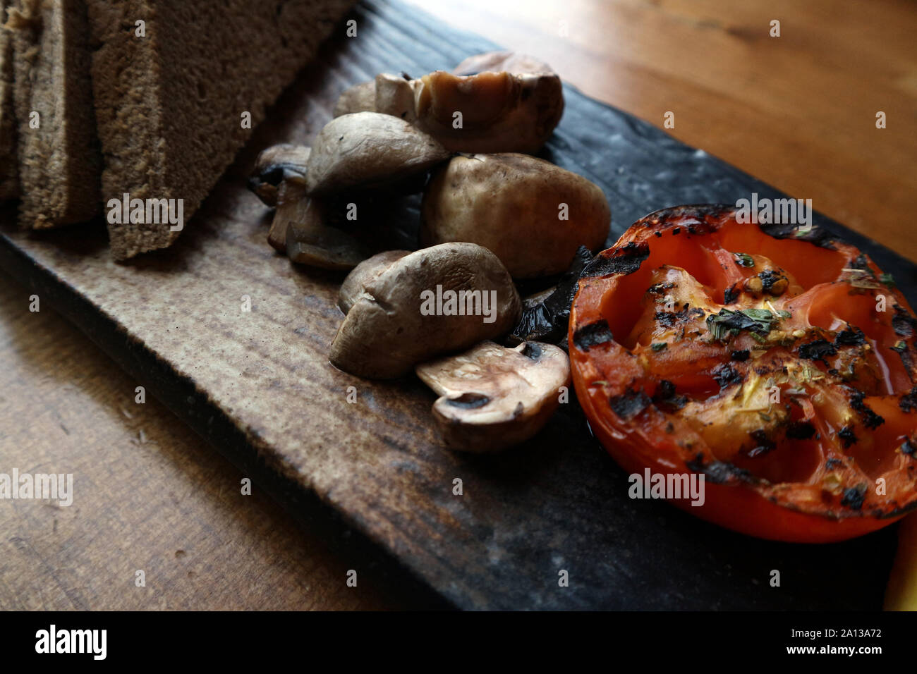 Close up di sano grigliate di pomodoro e di funghi con pane marrone Foto Stock
