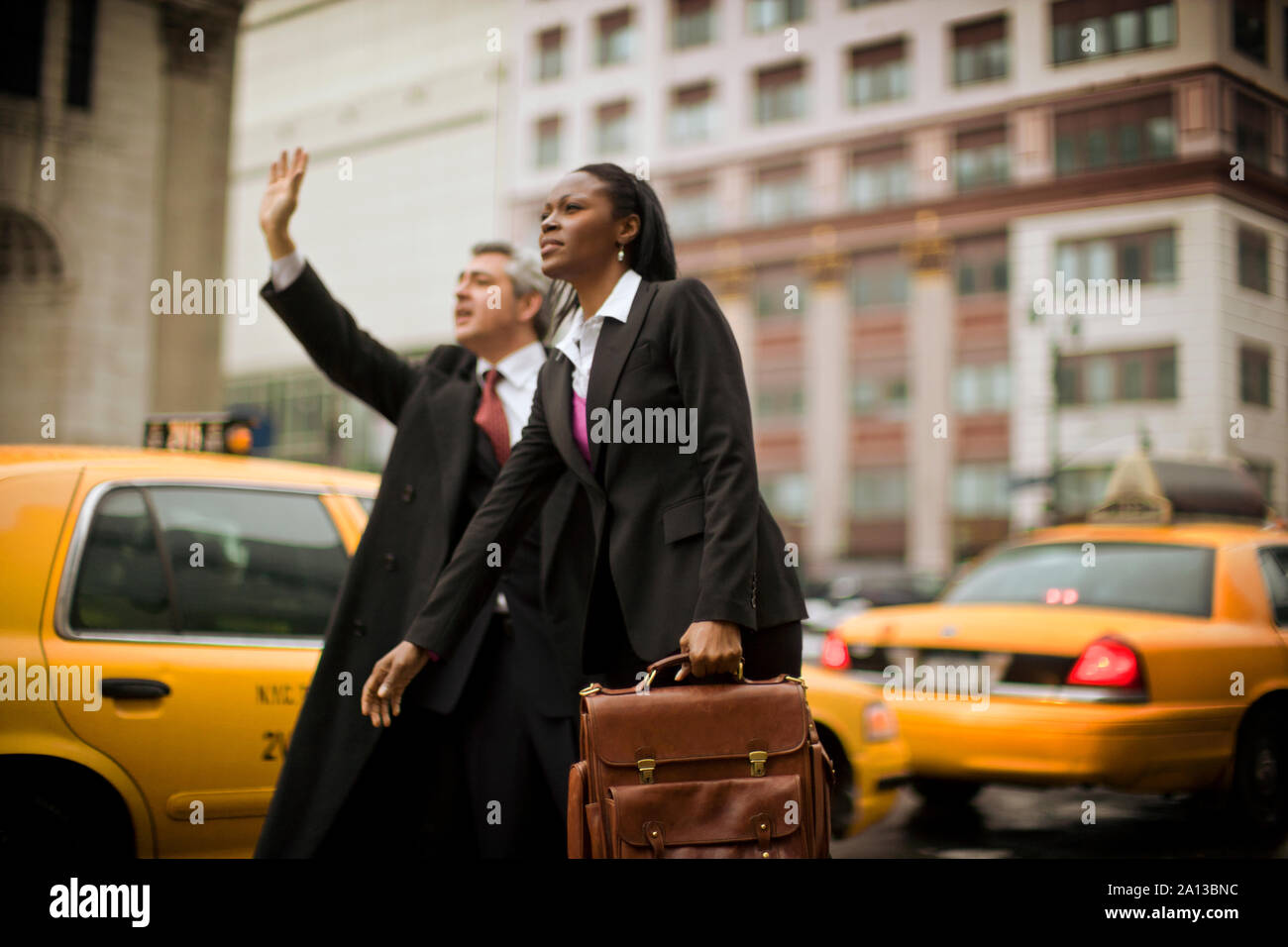 Due colleghi di lavoro salutando un taxi in una strada della citta'. Foto Stock
