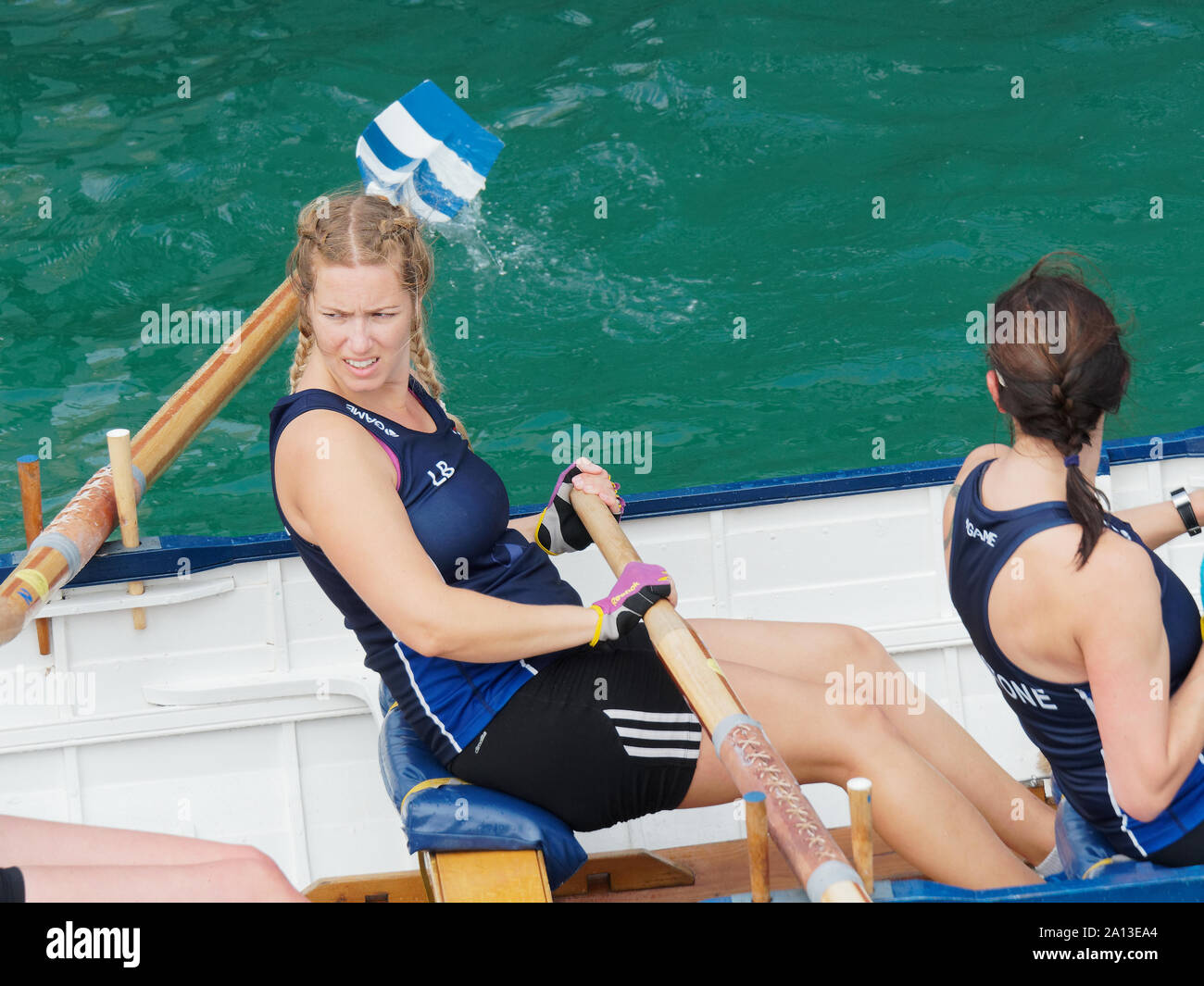 Le donne canottaggio in squadre di sei nei tradizionali costruiti a mano gig pilota barche. l annuale west country evento richiama squadre provenienti da Europa (London Cornish) Foto Stock