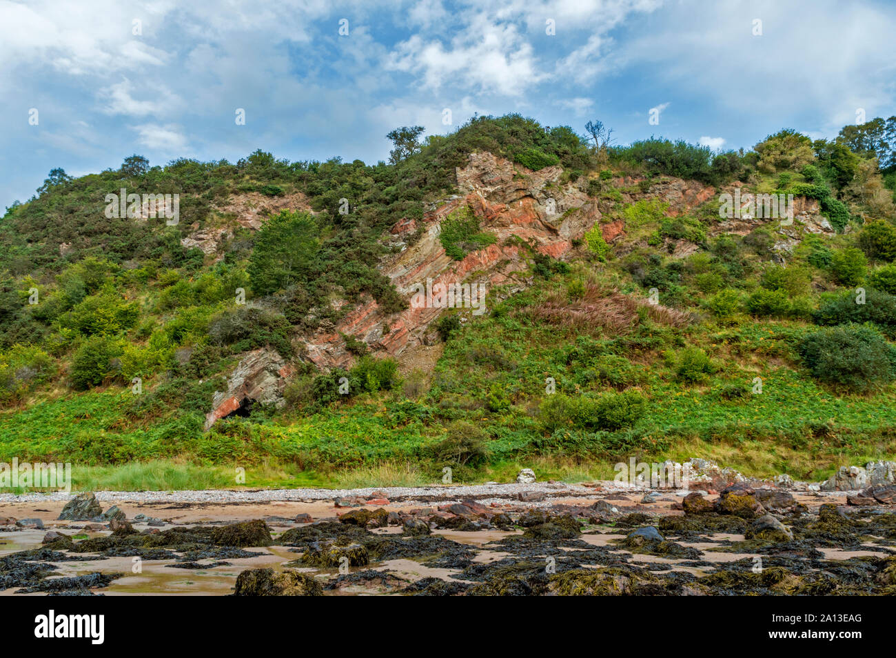 ROSEMARKIE AI PIEDI DI CROMARTY Black Isle Scozia vista della grotta CAIRDS E RED ROCK formazione dalla spiaggia con la bassa marea Foto Stock