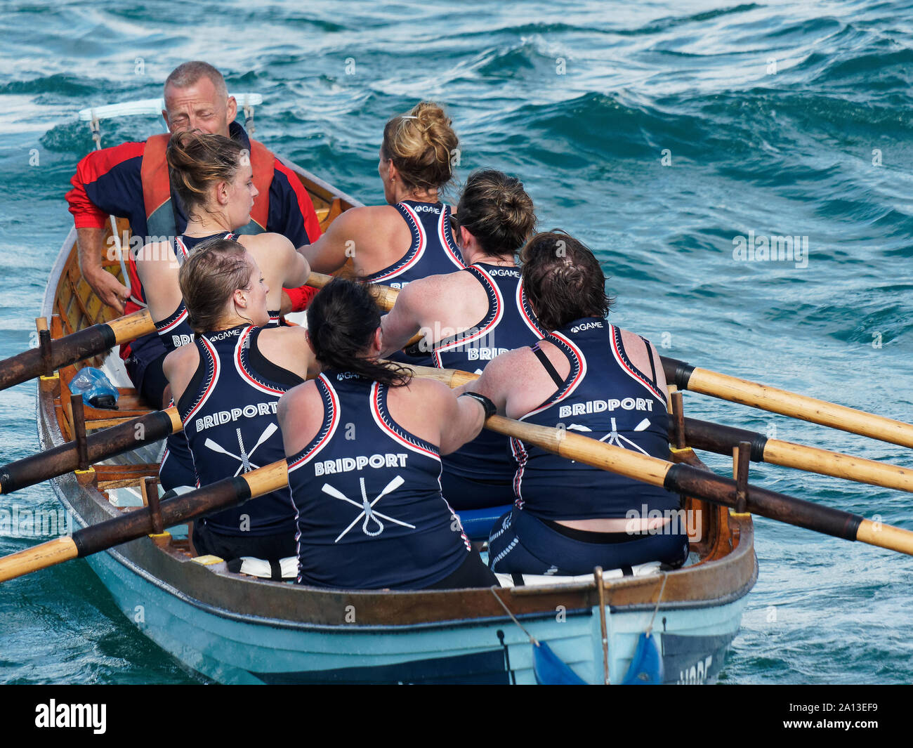 Le donne canottaggio in squadre di sei nei tradizionali costruiti a mano gig pilota barche. l annuale west country evento richiama squadre provenienti da Europa (London Cornish) Foto Stock