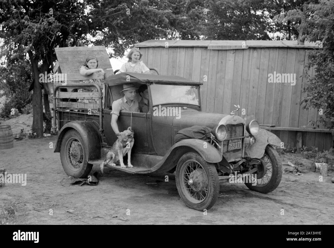 Grande Depressione era fotografia di una famiglia migrante in un pranzo auto si prepara a lasciare. Foto Stock