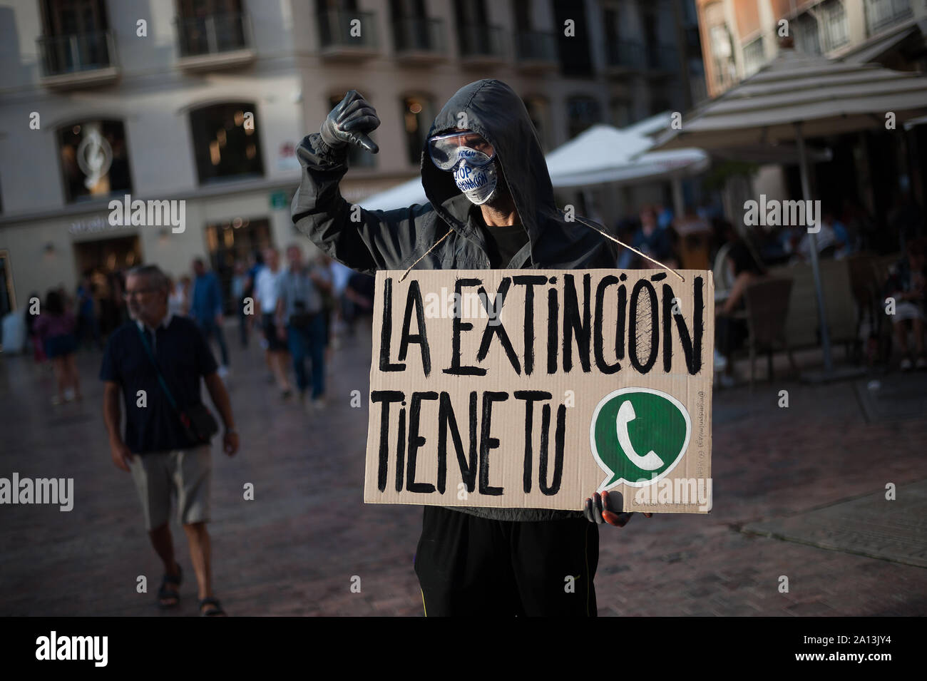 Un attivista mascherato che indossa una targhetta durante la protesta.Membri di 'Malaga's Alliance per l emergenza clima' fatta una performance denunciando l estinzione delle specie causati dal cambiamento climatico e inquinamento di plastica come parte di avvenimenti che segnano il "clima settimana" in relazione al clima globale colpisce. Foto Stock