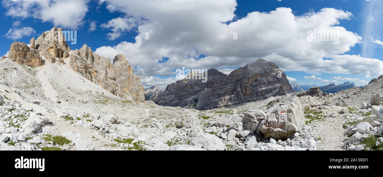 Panorama selvaggio paesaggio di montagna con picchi rocciosi e un sentiero escursionistico di marcatore e percorso in primo piano nelle Dolomiti italiane Foto Stock