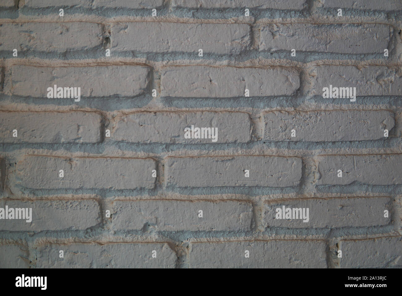 Close up di bianco muro di mattoni di tessitura grossolana e allineamento irregolare. Foto Stock