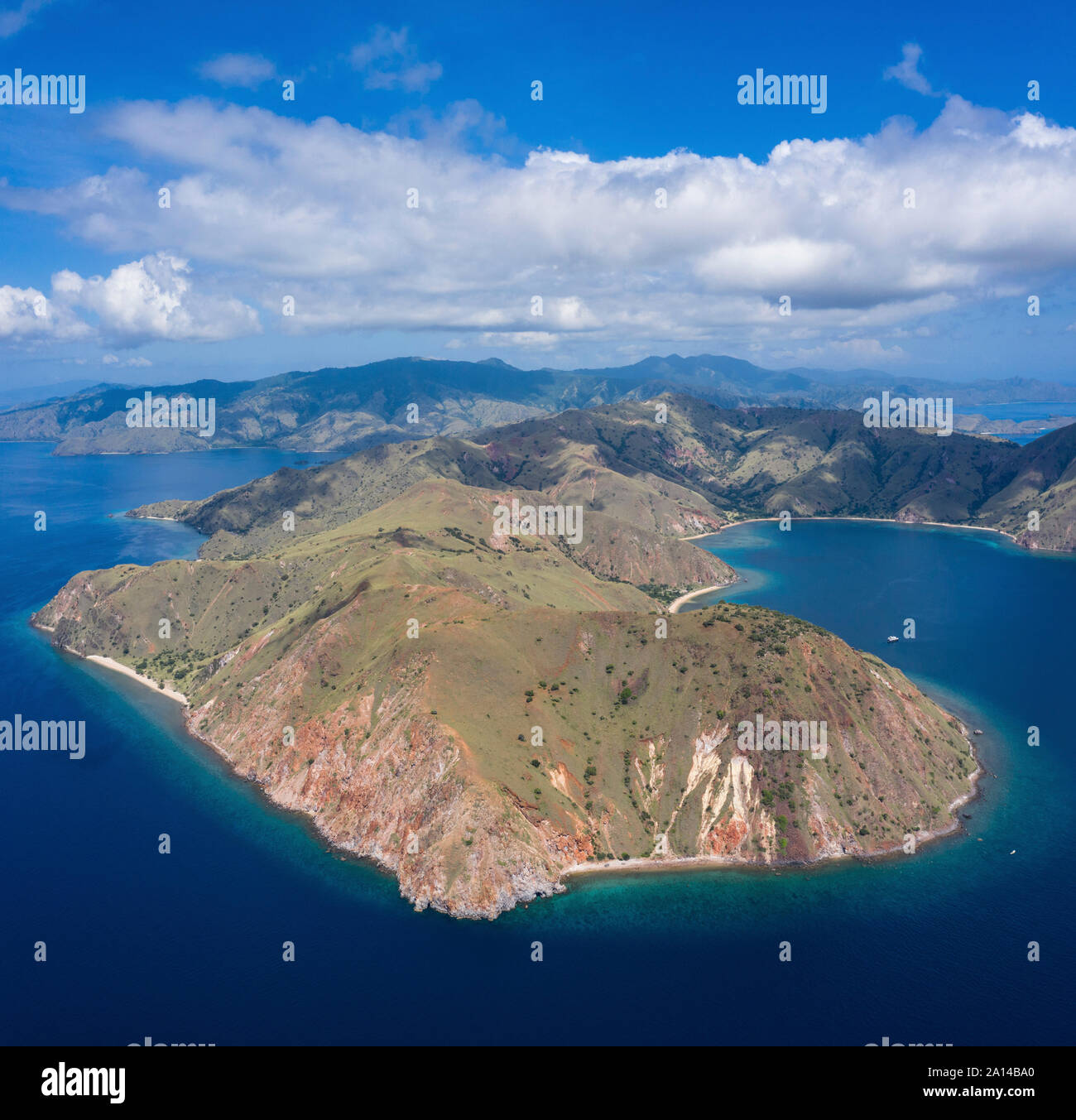 Vista panoramica di un'isola idilliaca e barriera corallina nel Parco Nazionale di Komodo, Indonesia. Foto Stock